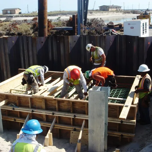 Construction crew installing plywood formwork on site